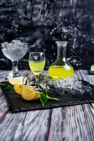 Italian typical digestive limoncello with fresh lemons and ice, selective focusの写真素材
