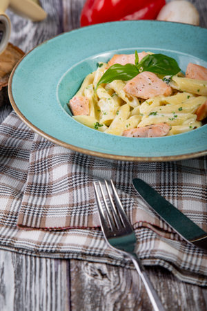 Italian pasta with fried salmon fillet stripes and salmon cream sauce. Food compositionの写真素材