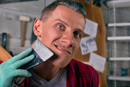 the worker shaves his ax on the wall with tools