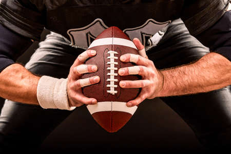American football sportsman player on stadium with lights on black background.の写真素材