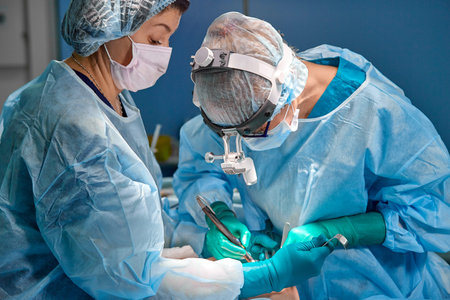surgery, medicine and people concept - group of surgeons at operation in operating room at hospitalの写真素材