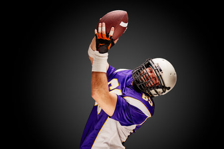 American football sportsman player on black background. Sport concept.