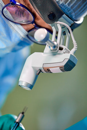 Close up portrait of female surgeon doctor wearing protective mask and hat during the operation....