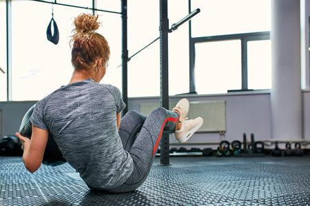 Woman doing exercises with fitball in fitness gym class. Engaging core abdominal muscles. Image...