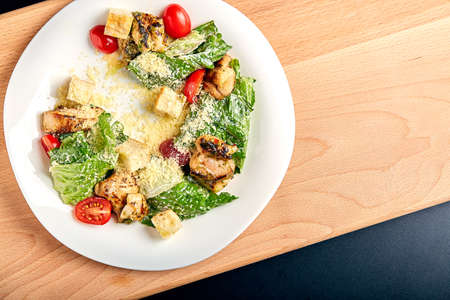 Caesar salad with chicken on wooden tableの写真素材
