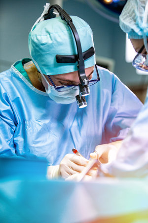 Surgeon and his assistant performing cosmetic surgery on nose in hospital operating room. Nose...