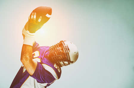 American football player in action with ballの写真素材