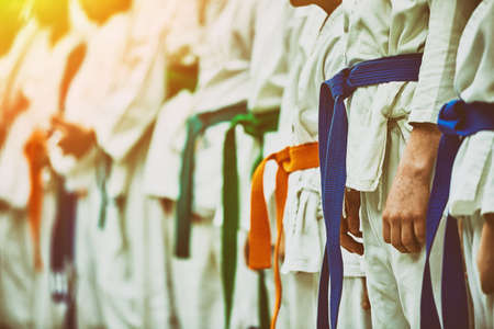 Concept karate, martial arts. Construction of students in the hall before training. Kimono, different belts, different levels of trainingの写真素材