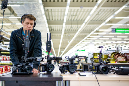 Videographer shooting a film or a television program in a studio with a professional camera,...