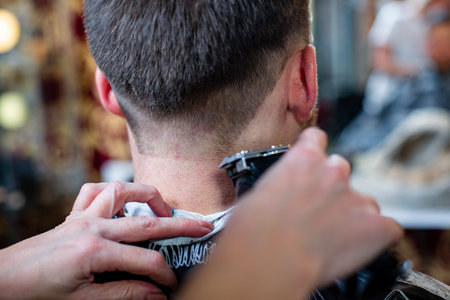 Close up of a male student having a haircut with hair clippers,