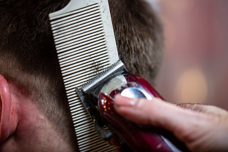 Close up of a male student having a haircut with hair clippers