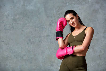 Beautiful young girl boxing gloves near the wall.の写真素材