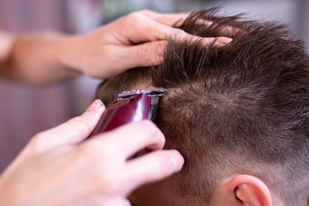 Close up of a male student having a haircut with hair clippers