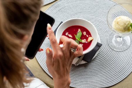 A girl makes selfie food while having lunch in a restaurant. Close-up copy space.