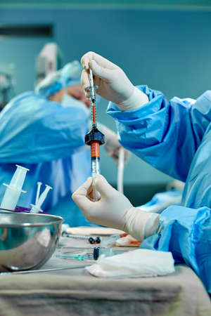 Hands hold syringes to carry fat during work. The operation to transfer fat from one part of the body to another. Platsichiskaya surgery, beauty, change of appearance.の写真素材