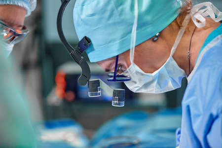 A surgeons team in uniform performs an operation on a patient at a cardiac surgery clinic. Modern medicine, a professional team of surgeons, health.の写真素材
