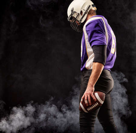 Portrait close-up, American football player, bearded without a helmet with the ball in his hands. Concept American football, patriotism, close-up.の写真素材