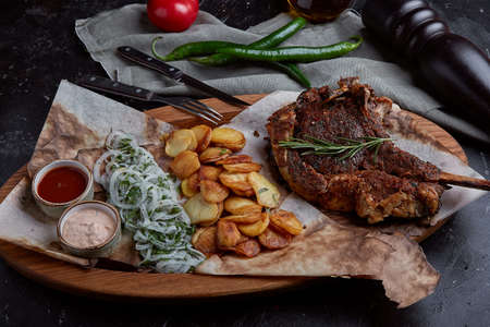 Tomahawk steak with vegetables and a knife on the table. Grilled meat with grilled vegetables and fresh vegetables on the table.の写真素材