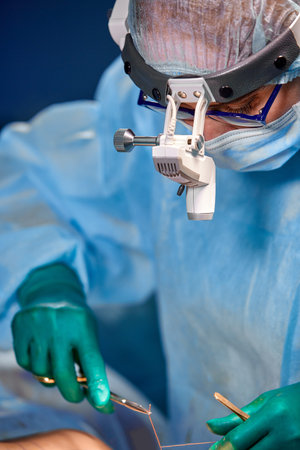 Close up portrait of female surgeon doctor wearing protective mask and hat during the operation....