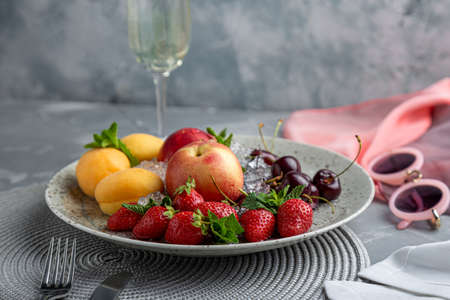 Healthy fruit platter, strawberries, apples, peaches, apricots on a dark gray wooden table, top view, close-up, selective focus.の写真素材