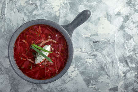 Traditional Ukrainian Russian borsch with sour cream on a bowl. A plate of red beetroot soup borsch on a gray marble background. Traditional Ukrainian cuisineの写真素材