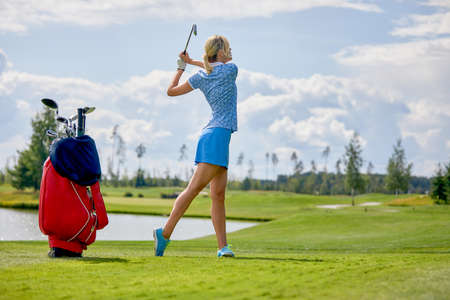Golf course, a beautiful girl getting ready to hit the ball. Lifestyle concept, golf concept, pursuit of excellence, craftsmanship, royal sport, sports banner.の写真素材