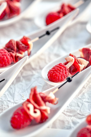 Delicious canapes hamon with raspberries. Concept of food, restaurant, catering, menu.