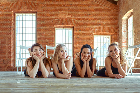 girls after training lie in the studio for fitness and posing for the camera. beautiful light,...