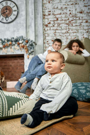 Christmas concept and children waiting for a miracle. Portrait of different kids on the background of Christmas decor, 15 minutes before Christmas Eve. Children awaiting Christmas and gifts, copy space.の写真素材