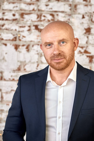 Bald man in a suit and tie on a white background
