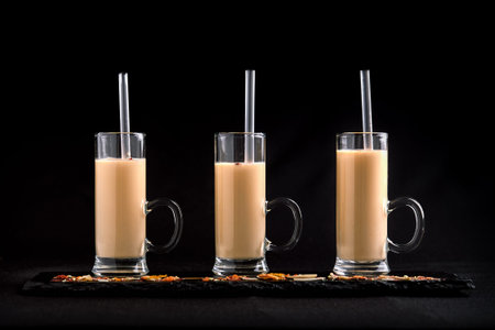 3 glasses with milkshakes on a dark background. Low key, food concept