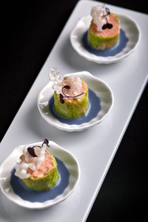 Baked salmon canapes with sauce, in white small saucers, concept catering food.