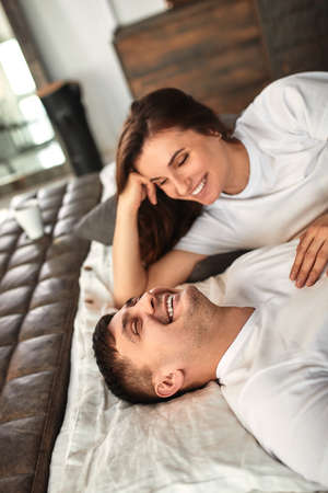 A young married couple awaiting a baby. Beautiful couple lying in the bedroom make plans for the birth of a baby. First child, postpartum, young family.の写真素材