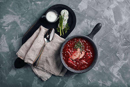 Hot soup. Borsch with red beans and braised beef. Comfortable food. Serving with brown bread and pork fat in a rustic style.の写真素材