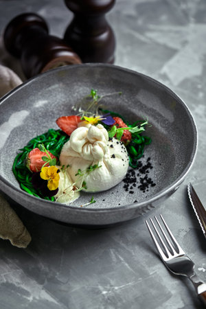 Burrata salad with strawberries and seaweed, on a gray background. Salad with buratta cheese on a...