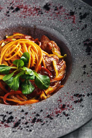 Spaghetti with vegetables tomato sauce and meat. Traditional italian food. Food photo. Dish from the chef. Beautiful presentation, macro shooting, close-upの写真素材