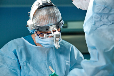 Close up portrait of female surgeon doctor wearing protective mask and hat during the operation....