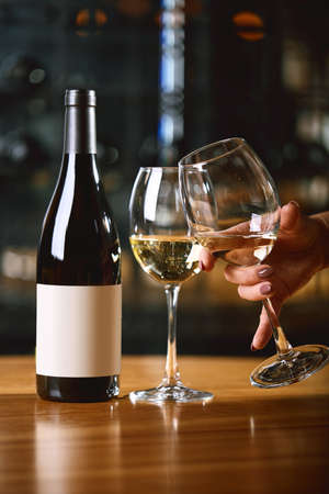 Bottles and glasses with wine on the table. Wine drinking culture concept. Apperetes and survivors. Copy space, dark background.の写真素材