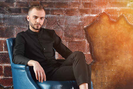 A pensive man in a stylish shirt in good physical shape looks at the camera. Be confident in...