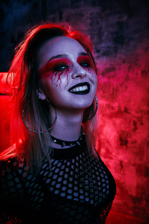 Female model in halloween outfit posing with on a red background. Gorgeous girl in clothes...