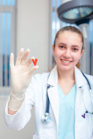 Doctor hands holding a heart, donation and implantation, medic, saving a life. Symbol of saving a...