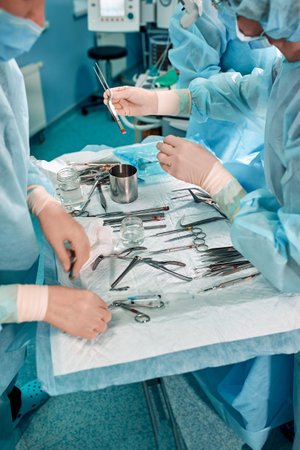 Sterile instruments on the operating table, a team of doctors lays out the instruments for the...