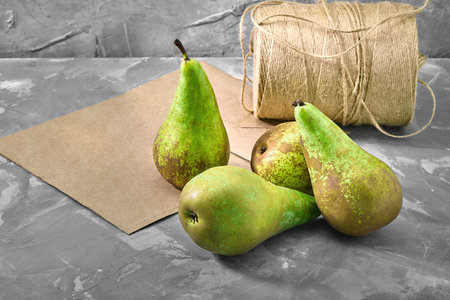 Green pears on a gray background with a paper bag for delivery, food delivery, environmental...