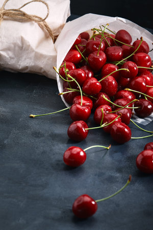 Fresh sweet cherry dark background, eco-friendly packaging. Close-up photo for grocery catalog...