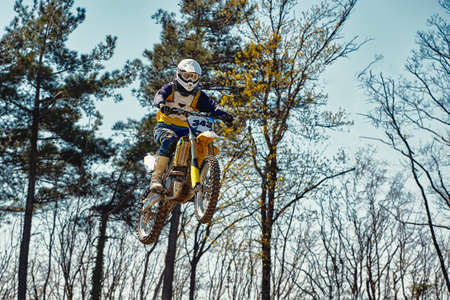 Motocross concept, a biker goes off-road making extreme skiing. In pursuit of adrinalin, sport concept. Dangerous sport.の写真素材