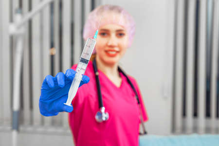 Disease vaccination concept, female doctor holding a syringe with a vaccine. The fight against the epidemic.の写真素材