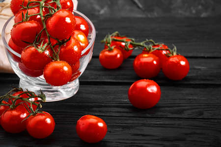 Fresh cherry tomatoes on a dark background, Close-up. Beautiful fresh tomatoes with dewdrops. Photos for grocery stores, grocery delivery.の写真素材