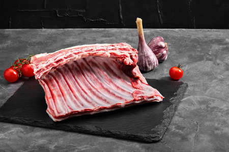 Organic lamb meat on the ribs. Fresh meat on the bone. copy space, gray background.の写真素材
