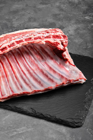 Organic lamb meat on the ribs. Fresh meat on the bone. copy space, gray background.