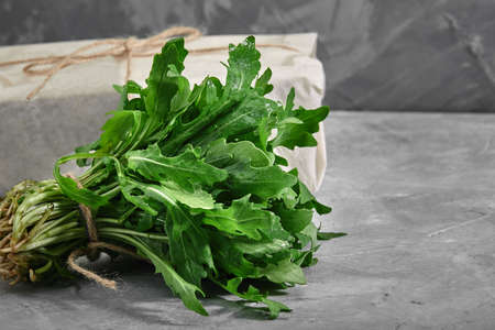 Fresh arugula leaves on concrete background. Healthy and fresh salad. Organic and natural food concept. Light background. Flat lay.の写真素材